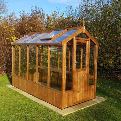 small wooden greenhouse on lawn