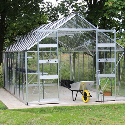 large silver aluminium greenhouse in garden